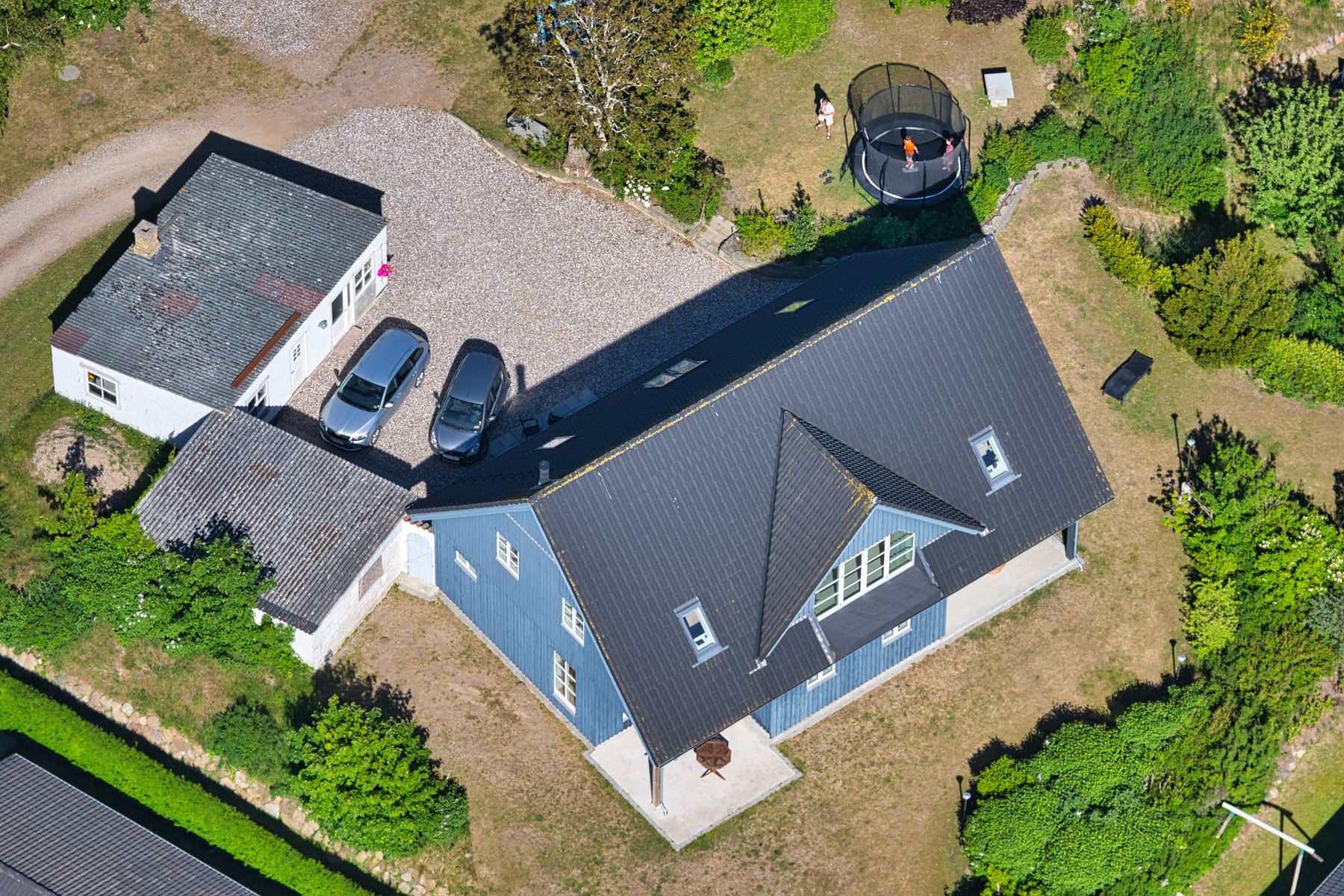 Villa med indkørsel, have og trampolin set fra luften